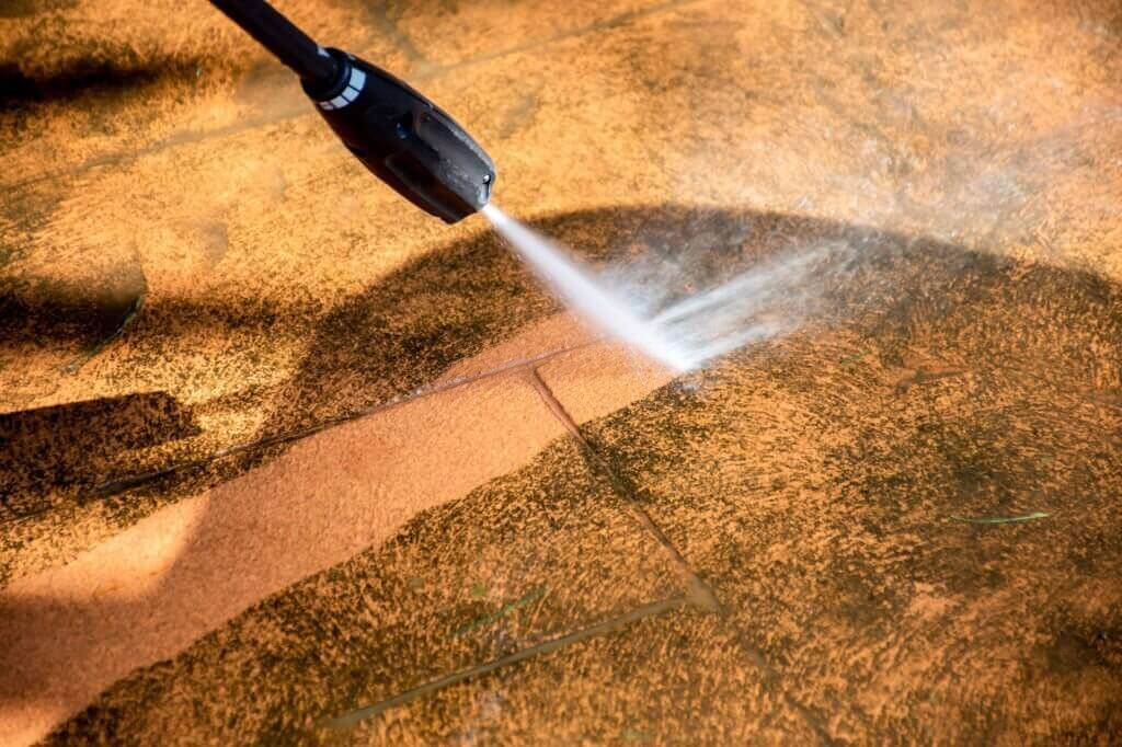 A professional pressure washing service in action, removing dirt and grime from exterior surfaces